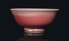 a red bowl sitting on top of a black table