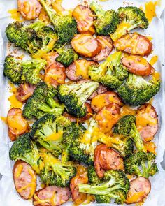 broccoli and sausage covered in cheese on a baking sheet