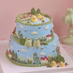 a three tiered cake decorated with animals and trees