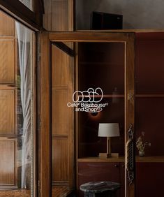 an open door leading into a room with wood paneling and glass doors on both sides