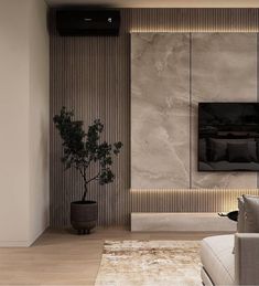 a living room with a couch, chair and television on the wall next to a potted plant