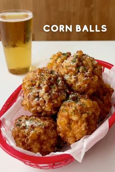 corn balls in a red basket next to a glass of beer on a white table