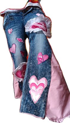 two jeans with pink hearts on them and one has torn off the bottom, while the other