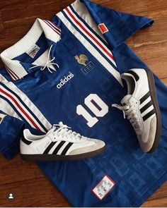 an adidas jersey and sneakers are laying on the floor next to a pair of tennis shoes