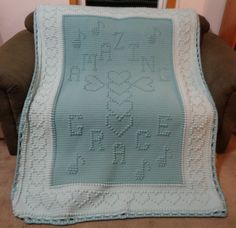 a crocheted blanket sitting on top of a couch