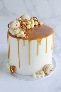 a white cake with caramel drizzled on top and candies all over it