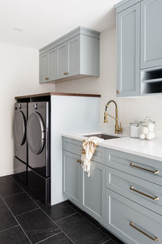 a washer and dryer sitting in a kitchen next to each other on the counter