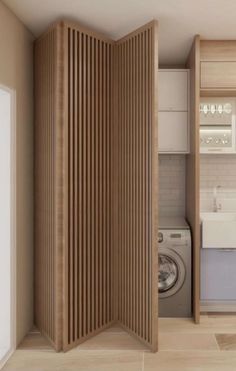 an open door to a washer and dryer in a small room with wood paneling