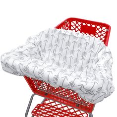 a red shopping cart with a white blanket on it's seat and the bottom part of the cart has an arrow pattern