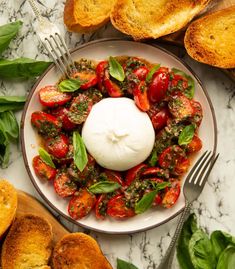 a white plate topped with lots of food next to bread