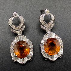 HUGE 15.90 Carats, Thai yellow sapphires and 3.22 carats of F/VS, natural diamonds, set in handmade 16 grams, 18K solid white gold earrings. ONE OF A KIND HANDCRAFTED EARRINGS. IN CASE OF RETURN FOR US BUYERS. BUYERS MAY SEND THE ITEMS BACK TO OUR US-BASED OFFICE IN SALT LAKE CITY, UTAH Our jewelry are specially designed, and are delicately handcrafted by local Thai, professional goldsmiths, who have had decades of experience in creating fine jewelry. SUGGESTED RETAIL VALUE: 12,000 THE ITEM YOU Orange Dangle Earrings For Formal Occasions, Orange Earrings For Anniversary In Fine Jewelry Style, Luxury Yellow Sapphire Jewelry With Brilliant Cut, Luxury Orange Drop Earrings, Luxury Orange Jewelry With Yellow Sapphire, Luxury Yellow Sapphire Jewelry, Formal Orange Gemstone Earrings, Hallmarked Yellow Sapphire Fine Jewelry, Elegant Yellow Diamond-cut Earrings