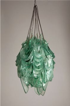 a bunch of green glass hanging from a ceiling