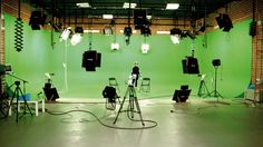 an empty studio with green walls and lighting equipment on the floor in front of it