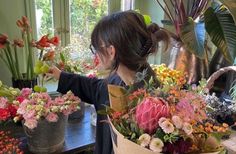 a woman arranging flowers in a flower shop