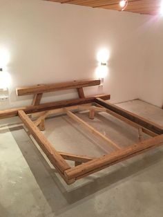 an unfinished bed frame in the middle of a room with two lights on each side