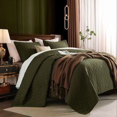 a bed with green sheets and pillows in a room