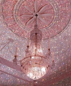 a chandelier hanging from the ceiling in a room filled with stars and lights