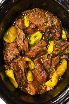 a slow cooker filled with meat and yellow pepper sauce on top of the crock pot