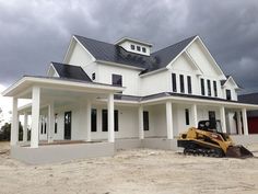 a large white house with a bulldozer in front