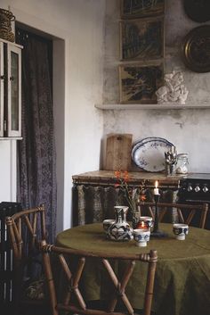 a table and chairs in a room with pictures on the wall