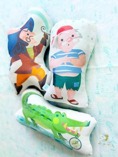 three pillows with cartoon characters on them