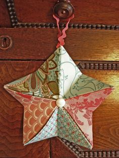 an origami star hanging from a door handle on a wooden door with beads