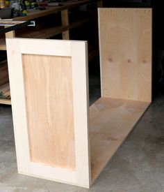 two unfinished plywood boxes sitting in a garage