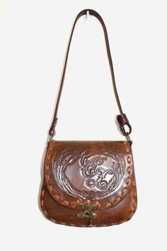 Tooled saddle bag in excellent condition!  Features; - genuine leather - adjustable cross body strap - interior pockets - 12" x 8" x 2" Leather Saddle Bag With Adjustable Strap, Leather Handheld Saddle Bag With Adjustable Strap, Hand Tooled Leather Crossbody Bag, Vintage Hand-tooled Pouch Bag, Vintage Brown Leather-backed Crossbody Bag, Classic Brown Hand-tooled Bag, Classic Hand Tooled Bags, Classic Brown Hand Tooled Bag, Classic Hand Tooled Brown Bag