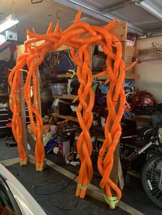 an orange sculpture in the middle of a garage