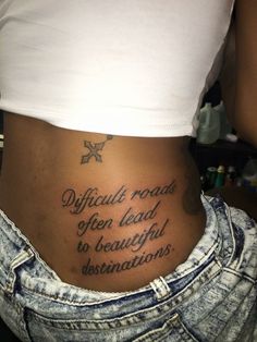 a woman with a tattoo on her stomach saying difficult roads often lead to beautiful destinations