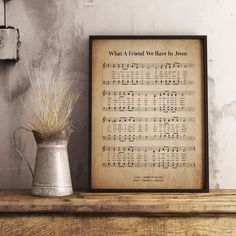 an old sheet music is displayed next to a potted plant on a shelf with the words what a friend we have in jesus