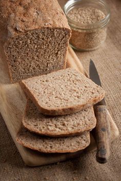 a loaf of bread sitting on top of a wooden cutting board next to a knife