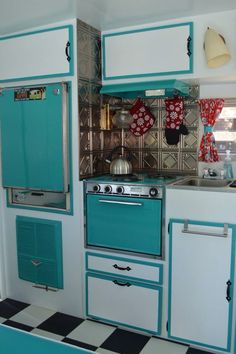 a kitchen with blue and white cabinets and black and white checkered flooring