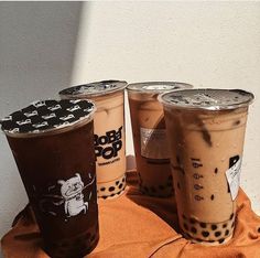 three iced coffees sitting on top of a towel