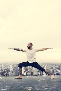 a man doing yoga on top of a building