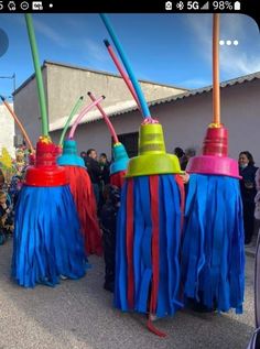 several colorful umbrellas are lined up on the street with people standing in the background