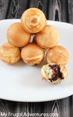 a white plate topped with mini pastries on top of a wooden table