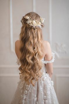 the back of a woman's head with long hair and flowers in her hair