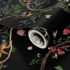 a black wallpaper with monkeys and flowers on the ground, in front of a dark background