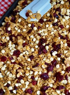 granola with cranberries and nuts in a pan on a checkered tablecloth