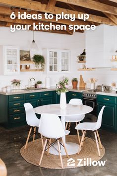 a kitchen with green cabinets, white chairs and a round table in the middle of the room