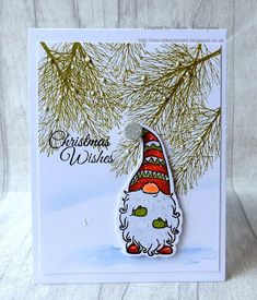 a christmas card with an image of a gnome wearing a hat and holding a pine branch