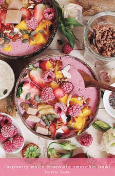 two bowls filled with fruit and granola on top of a wooden table next to other desserts