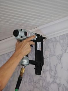 a man is using a drill to fix a hole in the ceiling with a power drill