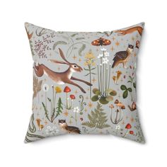 a decorative pillow with animals and plants on it