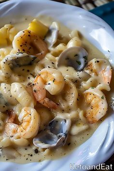 a white plate topped with pasta and shrimp