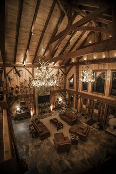 a living room filled with furniture and a chandelier hanging from the ceiling in front of a fire place