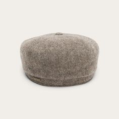 Designed in Europe, our Hatteras is defined by its impeccable stitching and sense of bold simplicity. This Virgin Wool Cap offers stylish cold weather coverage in a grey herringbone. The 8-piece construction and sewn-down brim are traditional features inspired by the iconic Newsboy Cap, which in turn took its cues from the Scottish Bonnet-style hats and Irish Flat Caps worn by farmers and laborers of the 14th-century. When those same workers eventually immigrated to the U.S.A. they brought their Classic Winter Beret, Classic Fall Herringbone Hat, Classic Fall Hat With Herringbone Pattern, Classic Winter Six-panel Beret, Classic Six-panel Winter Beret, Classic Gray Beret For Winter, Winter Hats With Herringbone Pattern And Curved Brim, Classic Herringbone Pattern Hat For Outdoor, Gray Six-panel Winter Hat