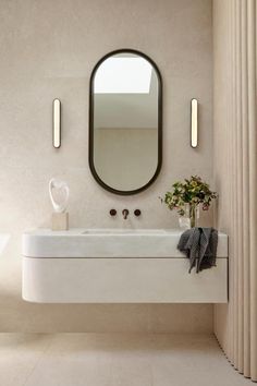 a white sink sitting under a mirror in a bathroom next to a wall mounted faucet