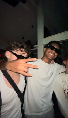 two young men wearing blindfolds and one is holding his arm around the other